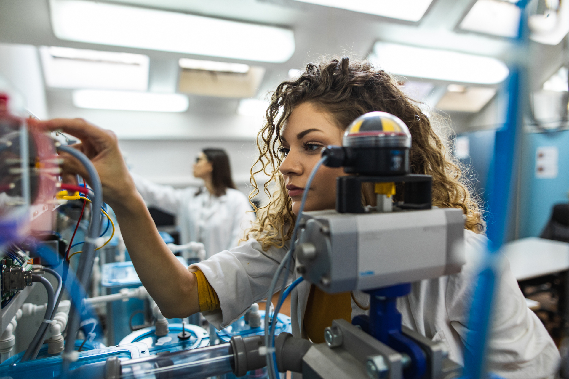 Technicienne en industrie travaillant sur des équipements de production